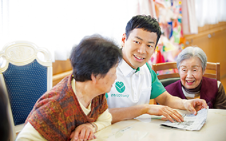 介護施設で高齢者と会話を交わす山本左近